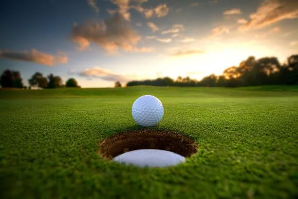 man in white shirt and blue shorts playing golf during daytime