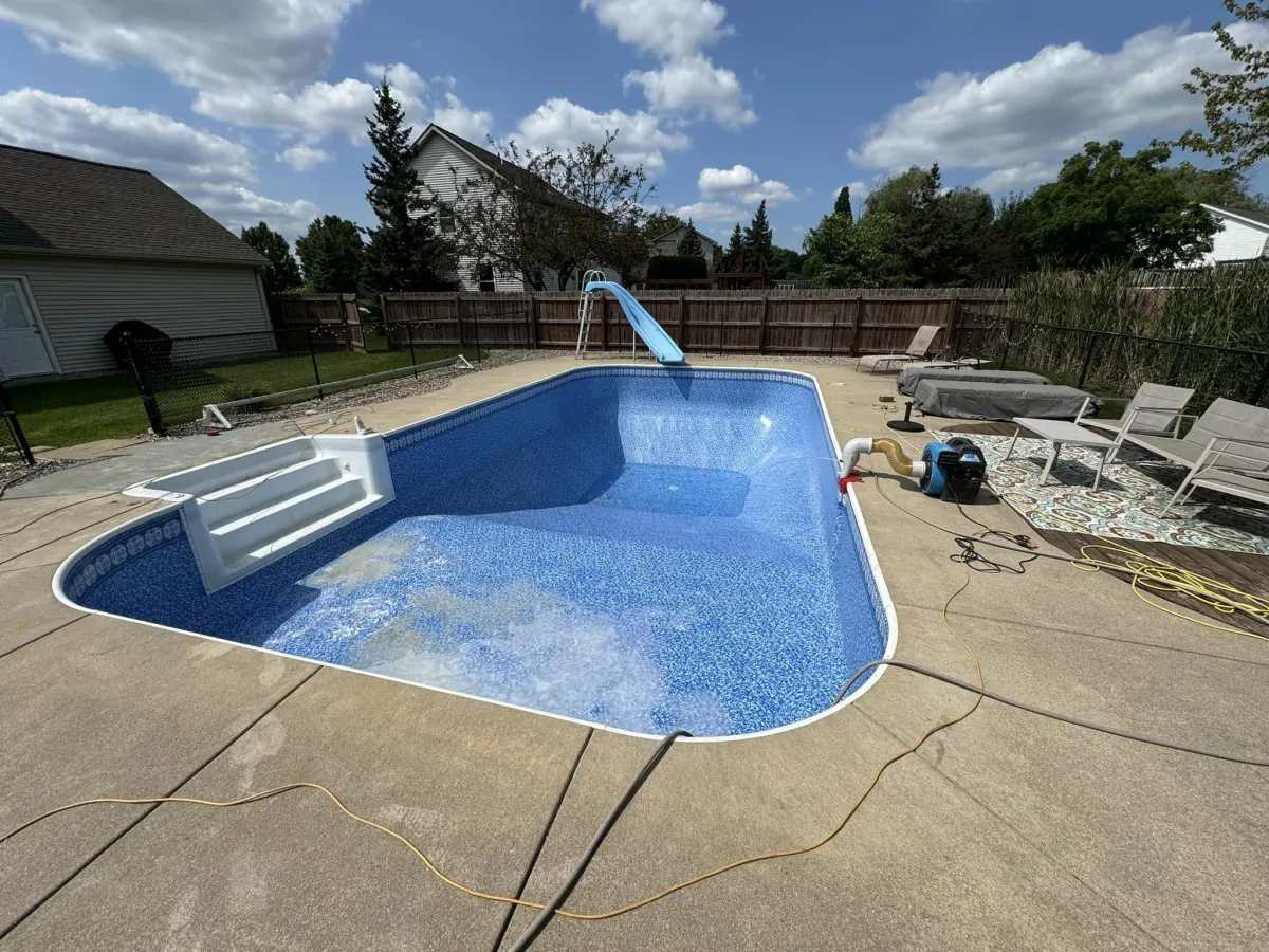 In-ground backyard swimming pool with a fresh, vibrant blue patterned vinyl liner installed by Fizer Pools.
