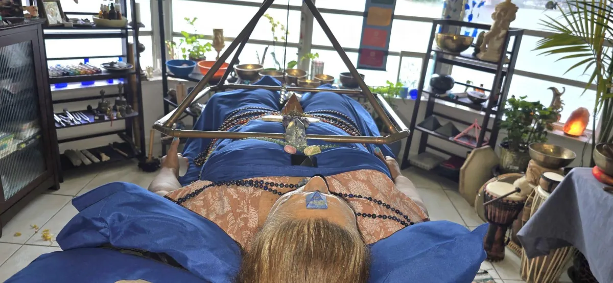 A person receiving chakra healing on a table with crystals