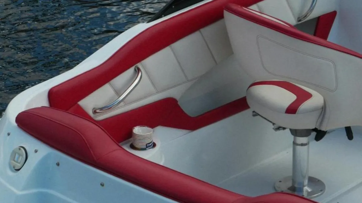 Boat in the water with upholstered siding and seats.