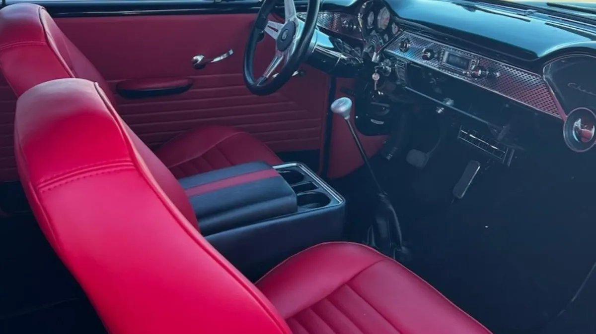 Classic car with red upholstered seats and door panel.