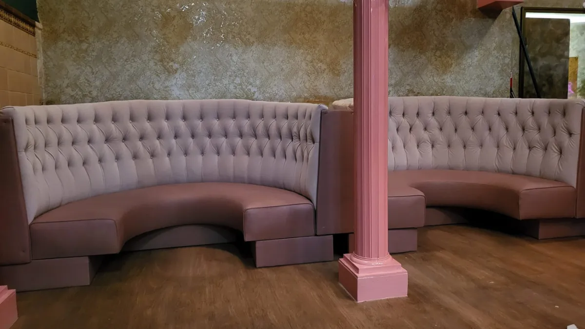 Restaurant seating upholstered with red and brown leather fabric.