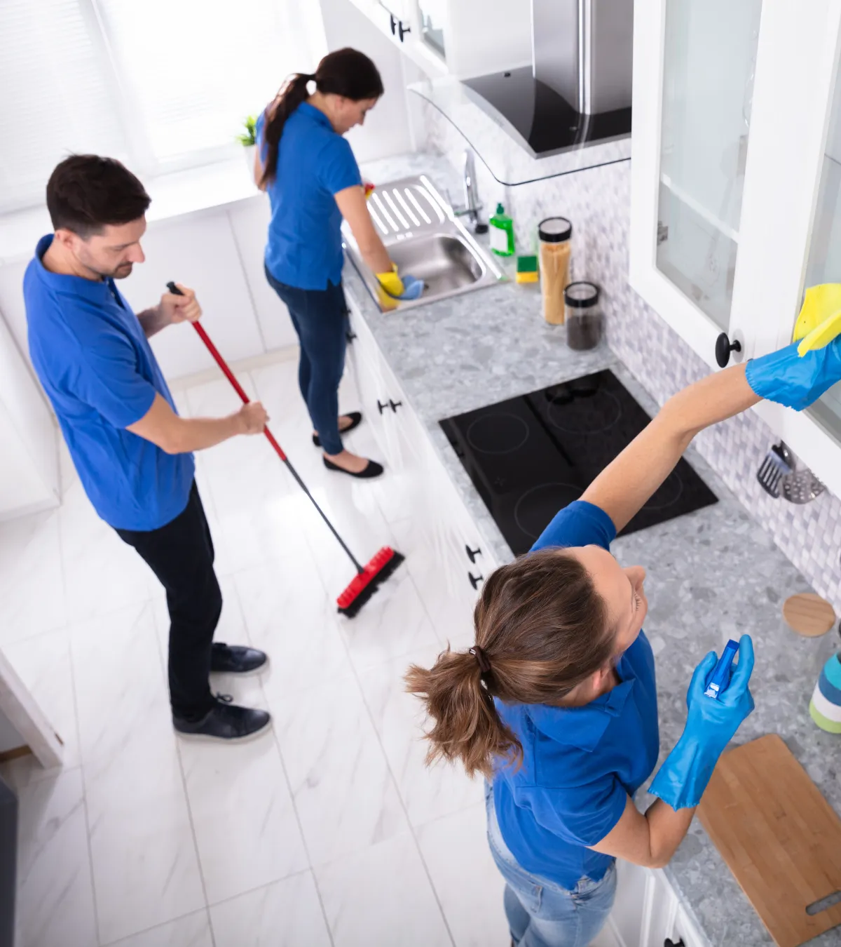 woman in white and blue floral long sleeve dress holding green broom