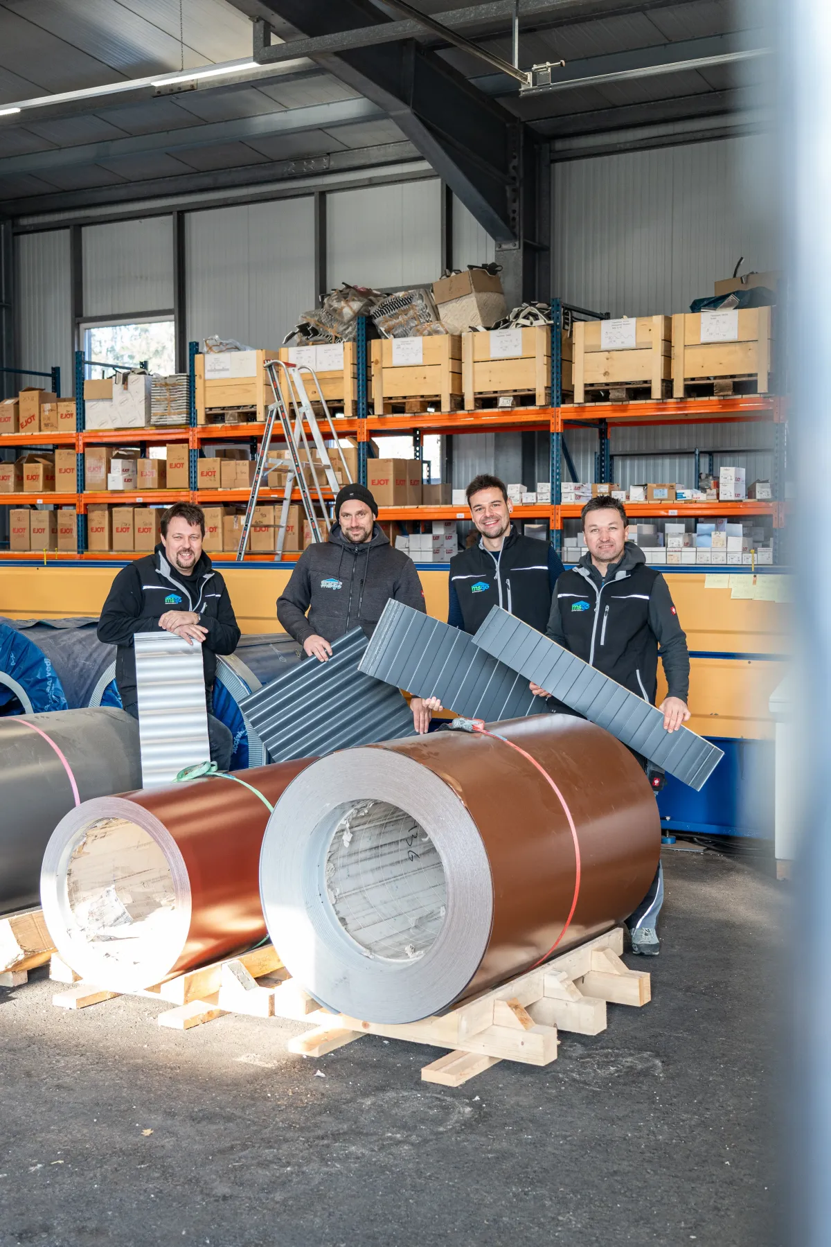 Mitarbeiter und Gerald, die zeigen aus welchen Materialien die Trapezbleche bestehen  d