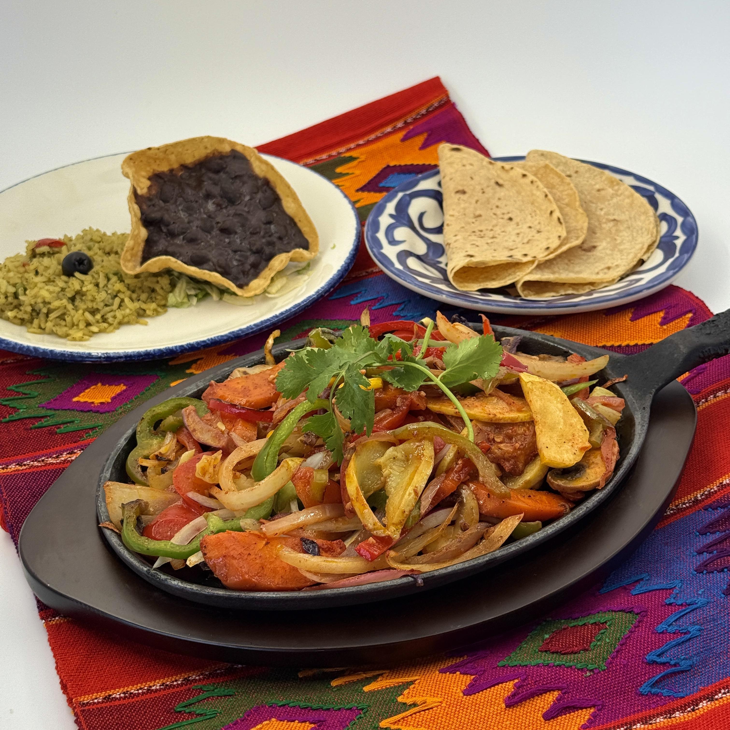 Vegetarian Fiesta Fajitas-Eight kinds of fresh vegetables sautéed and seasoned with achiote sauce. Served with soft tortillas, black beans, rice, and guacamole