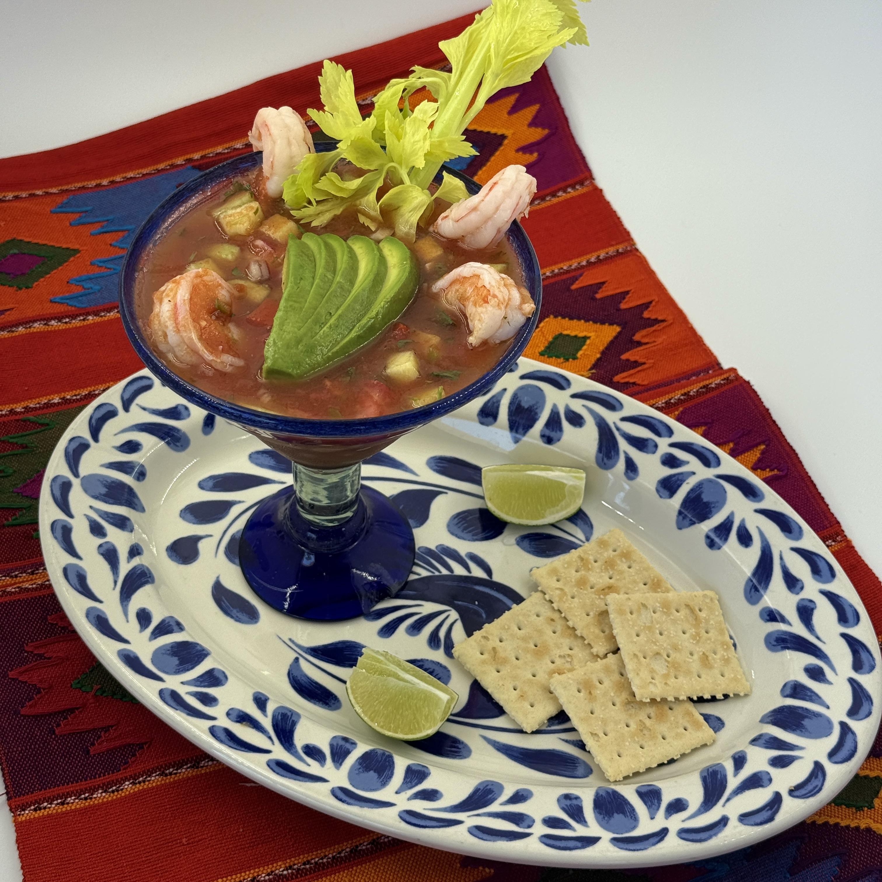 Mexican Shrimp Cocktail, Large wild caught shrimp mixed with generous chunks of creamy avocado, crisp cucumber, celery, and onion, all dressed in a mildly spicy cocktail sauce.