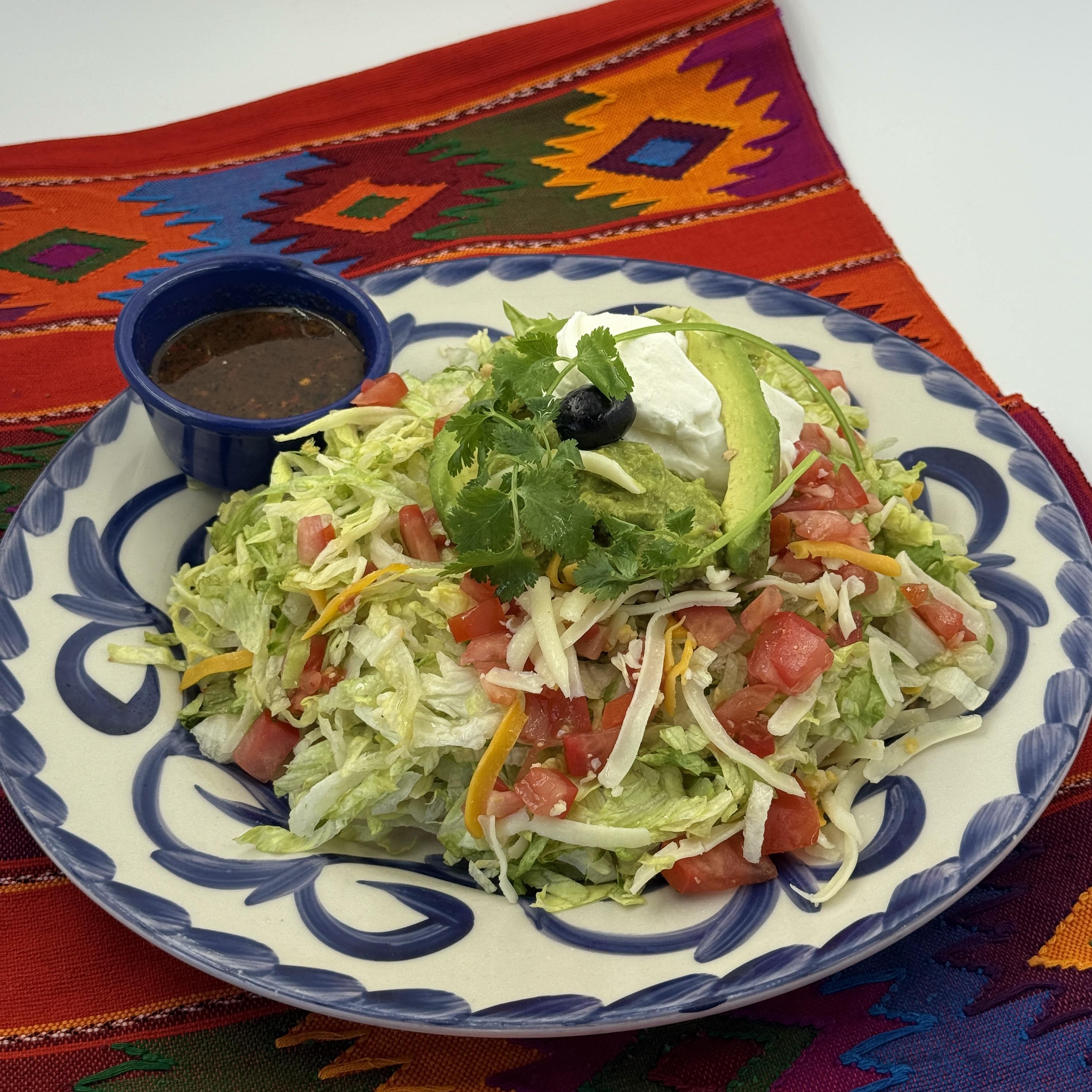 Taco Loco- A crispy flour tortilla packed with your choice of shredded beef or chicken, homemade frijoles, lettuce, cheese, and tomatoes. Accompanied by guacamole and sour cream on the side for a creamy touch. A satisfying crunch filled with vibrant flavors.