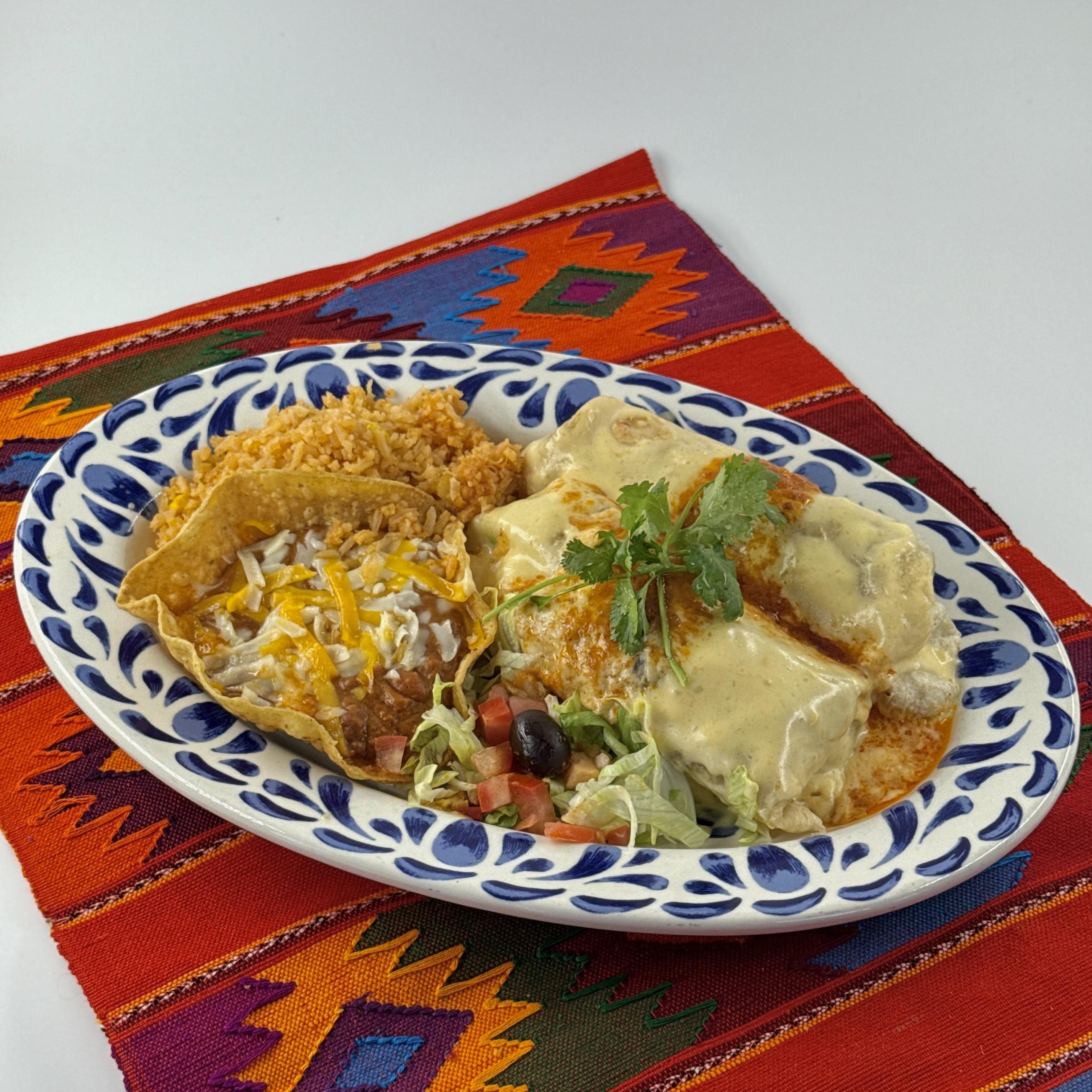 MACHACA BURRITOS, Two burritos combining shredded beef, scrambledeggs, green peppers, tomatoes and onions, topped with salsa ranchera and a special cheese sauce.Served with Mexican rice and refried beans