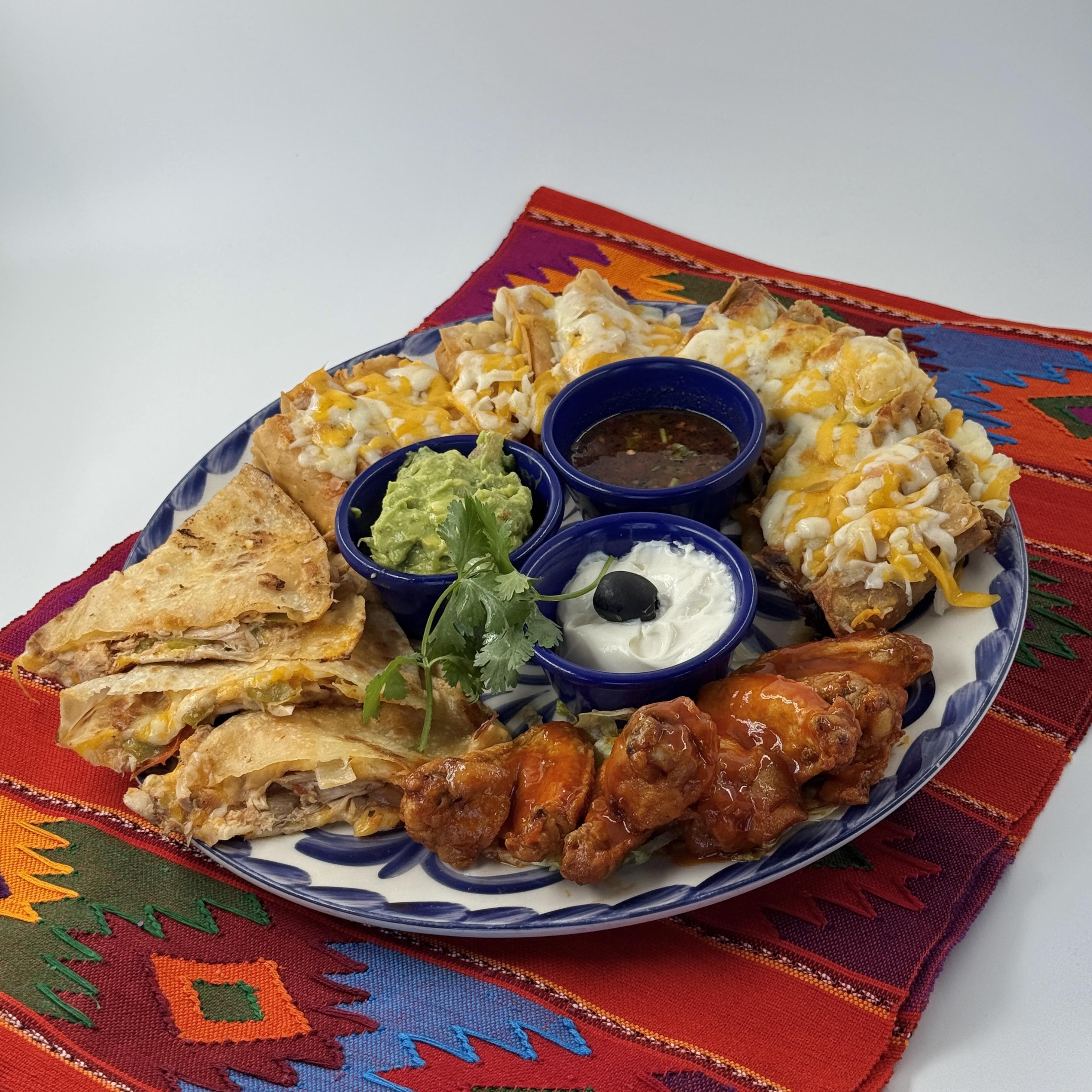 Chipotle Chicken Taquitos, A combination of tender pulled chicken in a smoky chipotle tortilla, deep-fried and topped with melted cheese. Served with creamy guacamole, tangy sour cream, and robust roasted salsa.