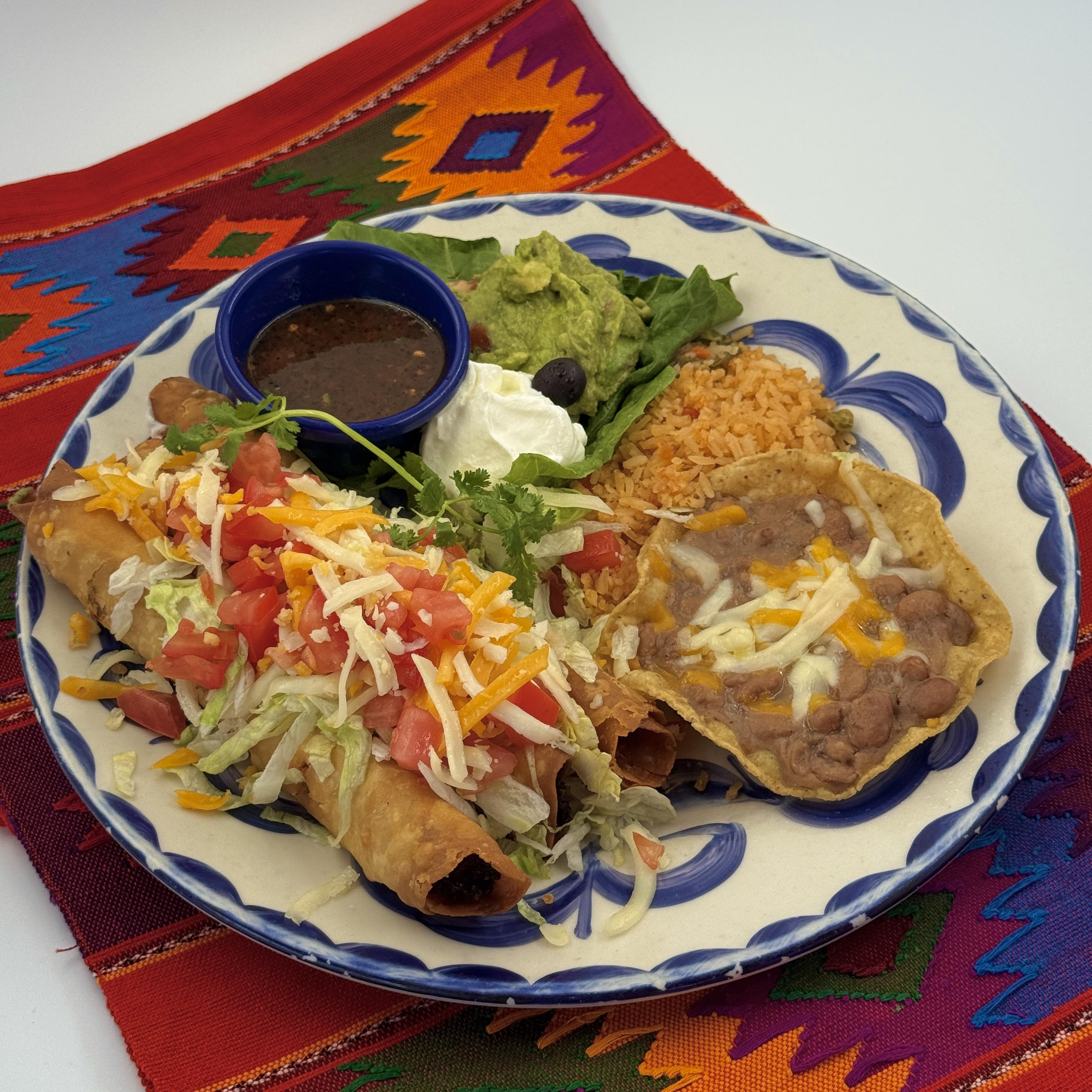 ESPECIAL DE FLAUTAS Three corn or flour tortillas, with shredded chicken, rolled, fried, and topped with lettuce, tomato, cheese, sour cream and guacamole. With rice, beans and salsa quemada.