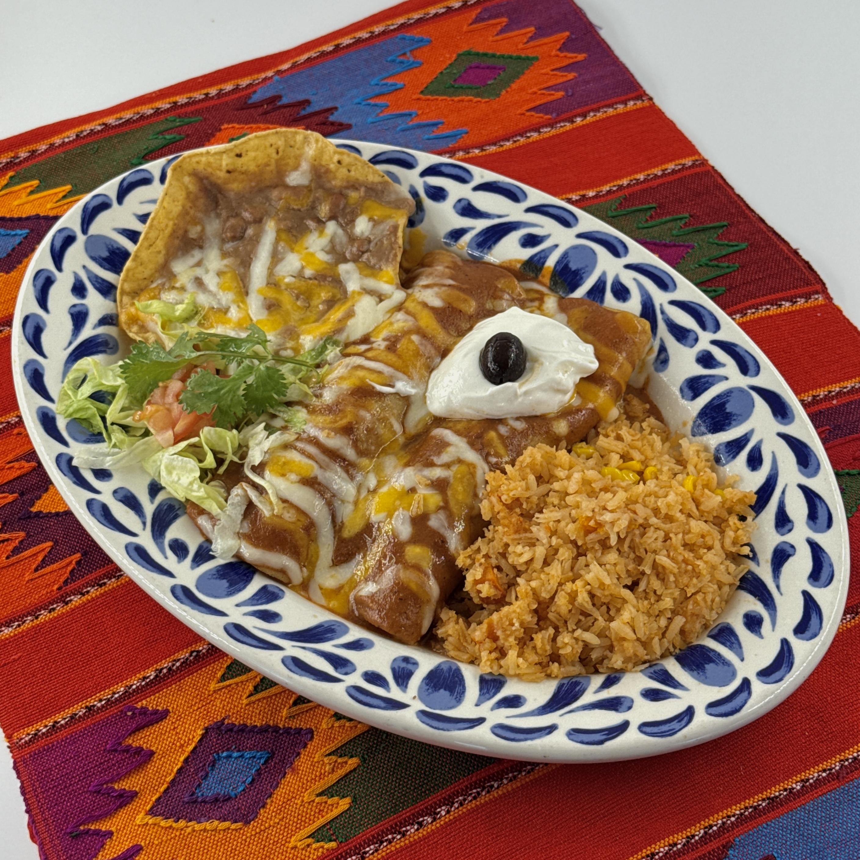 ENCHILADAS DE CARNE, Two shredded beef enchiladas, topped with salsa roja, melted cheese and sour cream. Served with rice and beans