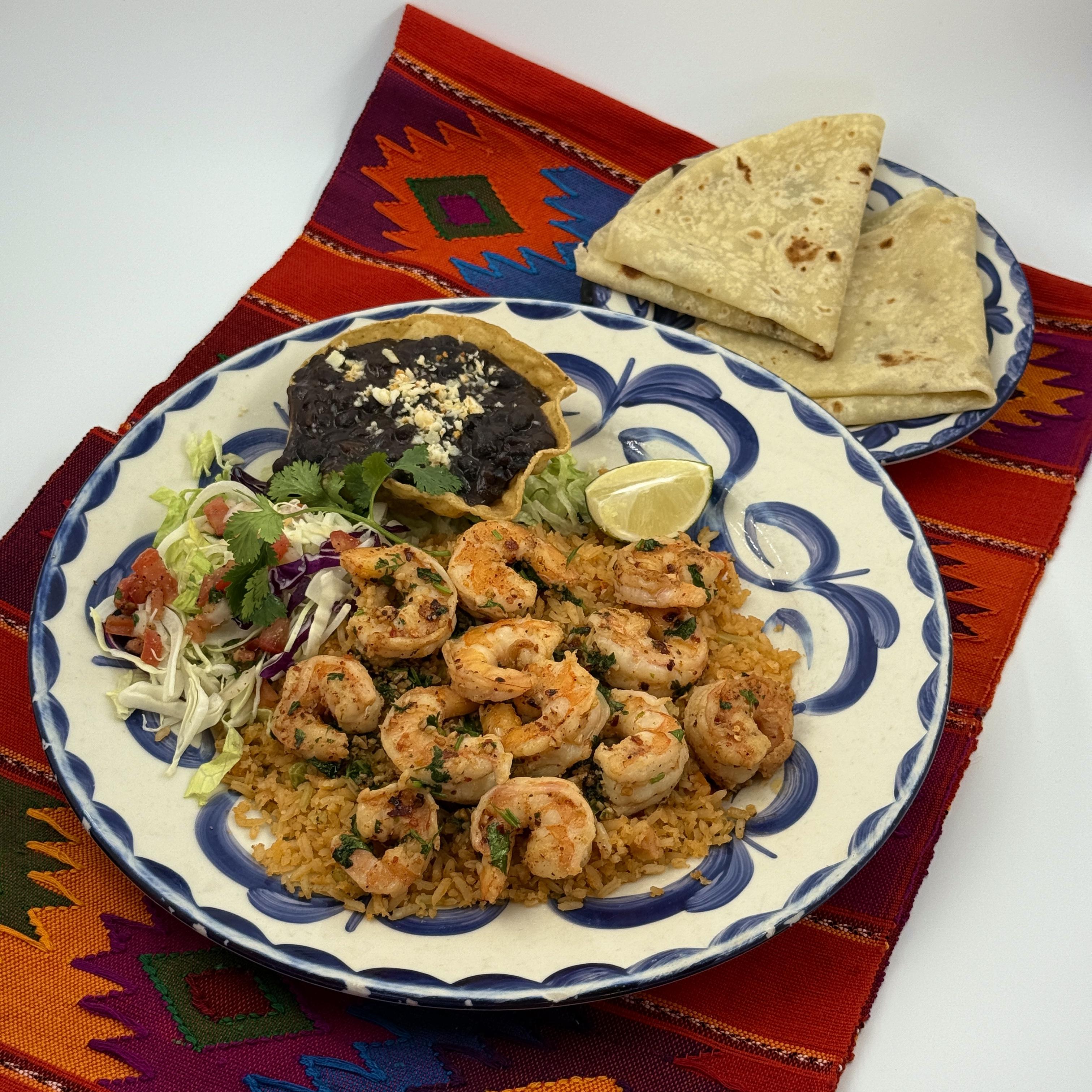 Tequila Lime Shrimp Pacific wild shrimp sauteed with tequila, lime, and butter, with garlic, crushed chili and cilantro atop Arroz Amarillo. Served with black beans.