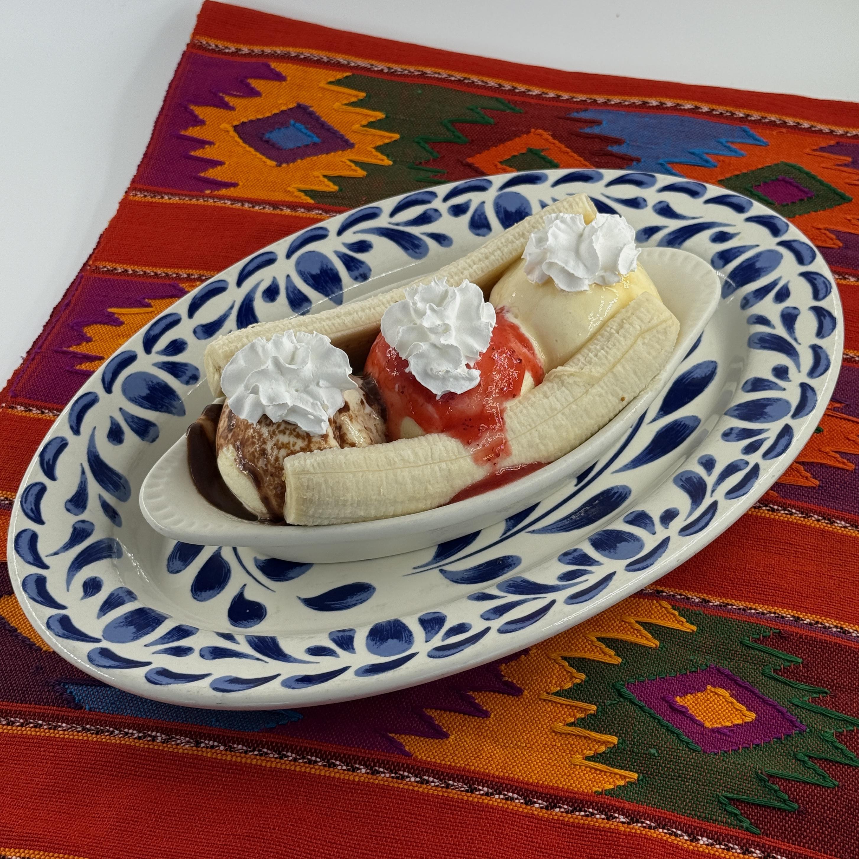 Mexican Banana Split Three scoops Three scoops of Hollandia vanilla ice cream topped with caramel sauce, Mexican chocolate sauce and strawberry sauce, nestled between two slices of banana. of Hollandia vanilla ice cream topped with caramel sauce, Mexican chocolate sauce and strawberry sauce, nestled between two slices of banana.