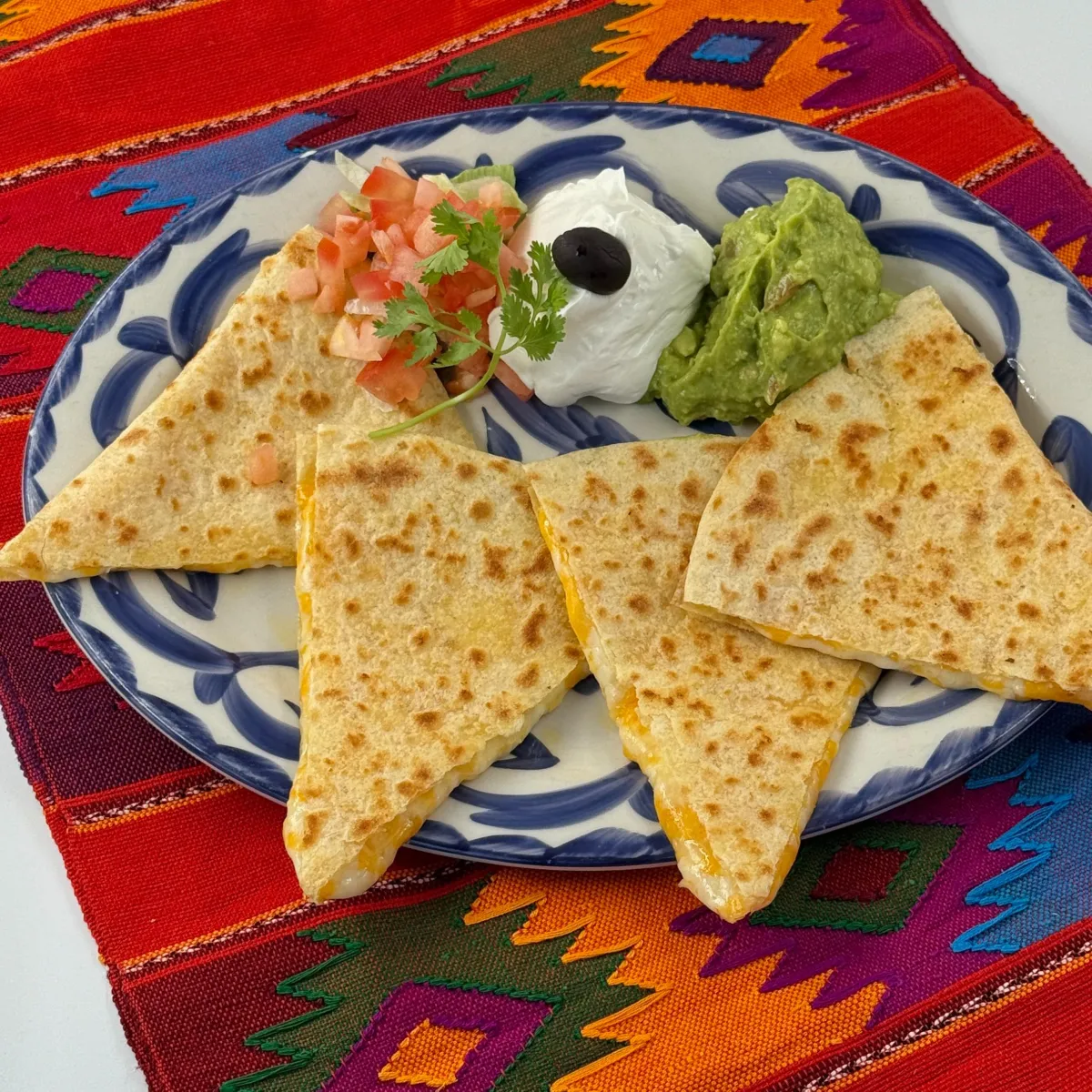 PICO Cheese  Quesadilla- Two warm, soft flour tortillas filled with melted gooey cheese and tender strips of Ortega green chiles, served with creamy fresh guacamole.