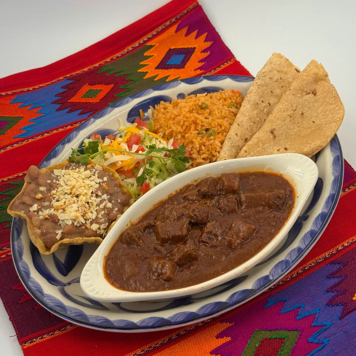 Chile colorado plate with Mexican rice, beans and flour tortillas