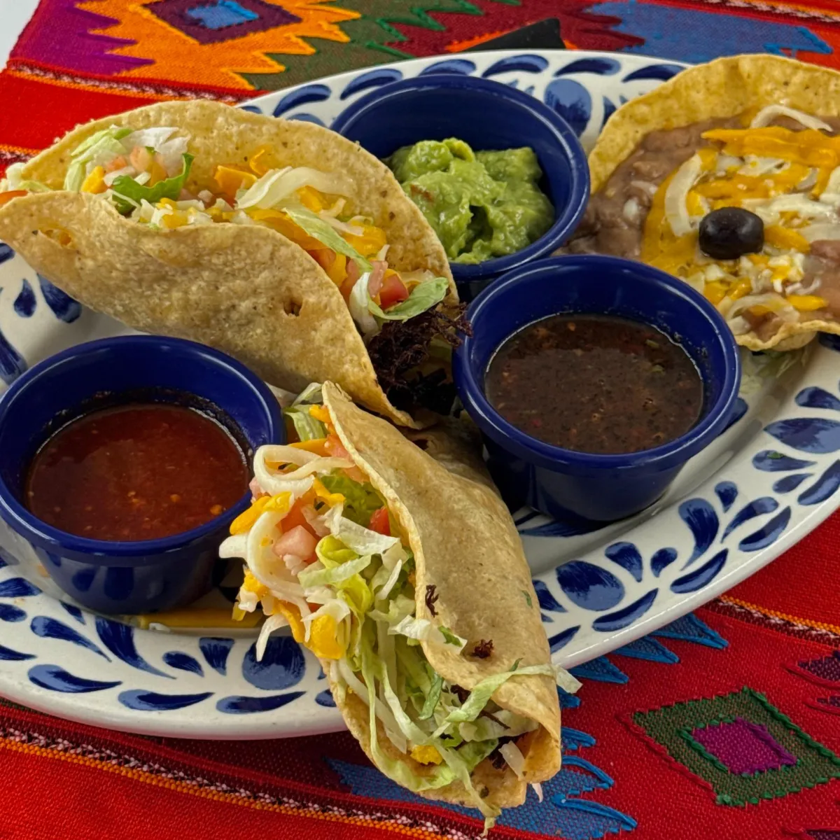 Crispy and soft tacos with salsas and guacamole