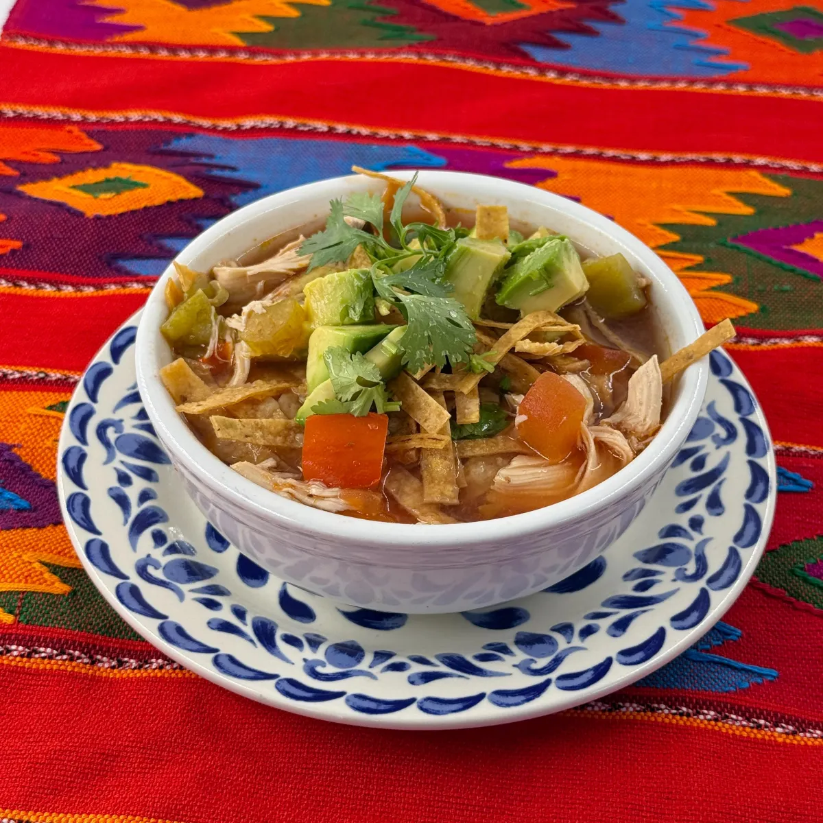 Chicken tortilla soup with vegetables, avocado and cilantro