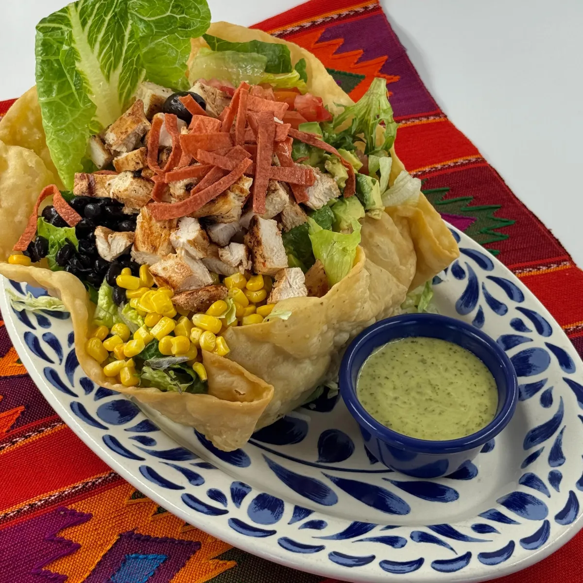 Mexican chopped salad with grilled chicken, corn and black beans in a tortilla bowl