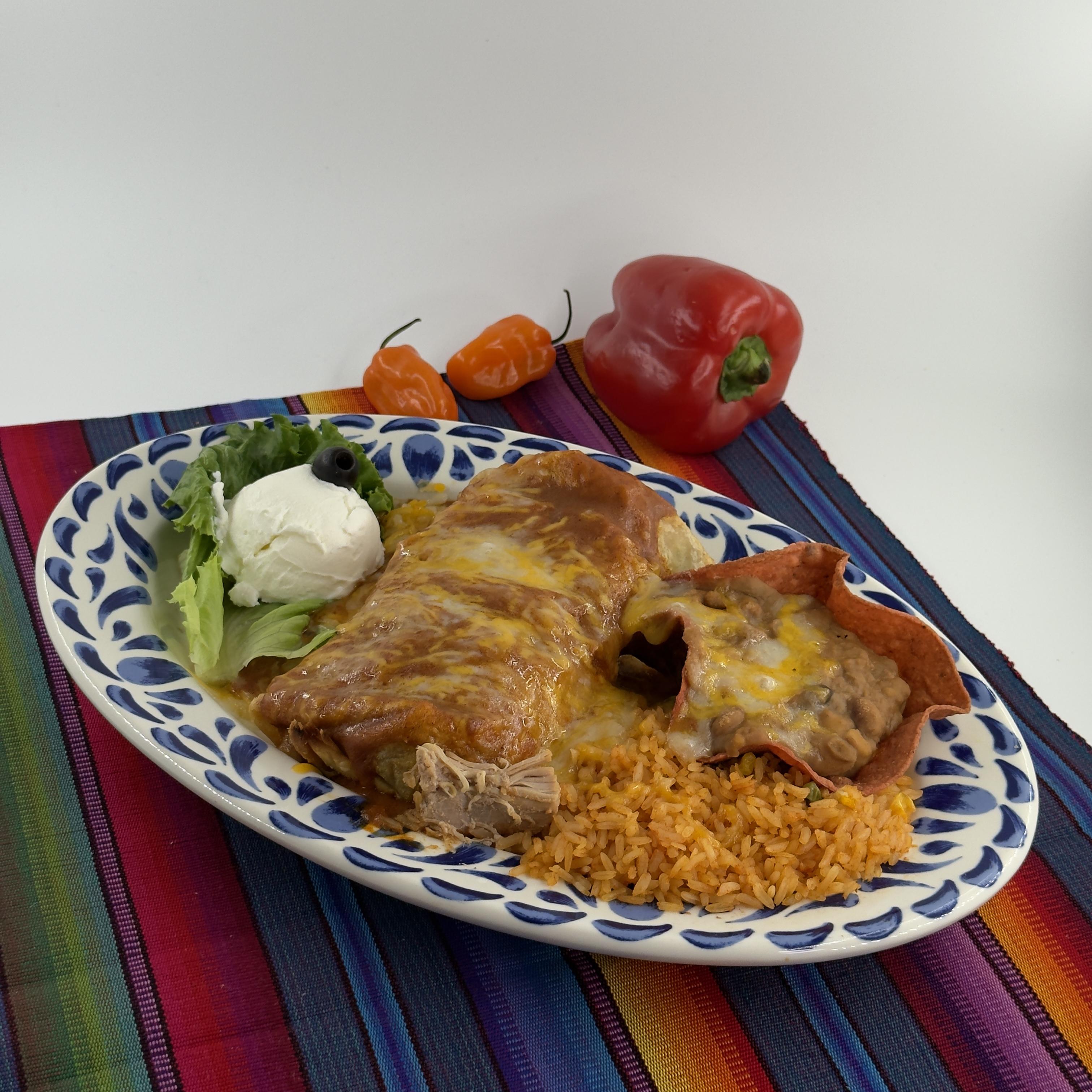 PICO Chimichanga, A large House-made flour tortilla filled with your choice of chicken or tender beef, coupled with hearty Mexican rice and homemade beans, all deep-fried to golden perfection. The chimichanga is then topped with our homemade Salsa Roja, a vibrant sauce that adds a flavorful kick. A sprinkle queso is added on top, followed by a dollop of smooth sour cream. Served with a side of fluffy Mexican rice and homemade beans.