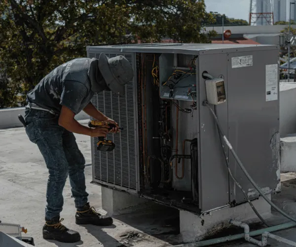 Homeowner checking vents for warm air coming from air conditioner