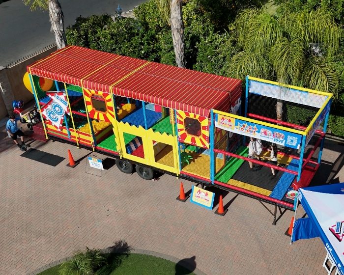 Playhouse on Wheels mobile playground trailer set up for a children's birthday party and community event.