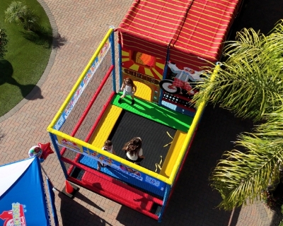 Playhouse on Wheels trampoline with girl jumping at a birthday party or celebration.