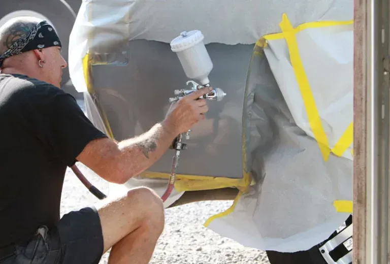 Technician performing professional RV body paint service on motorhome in St Charles Missouri