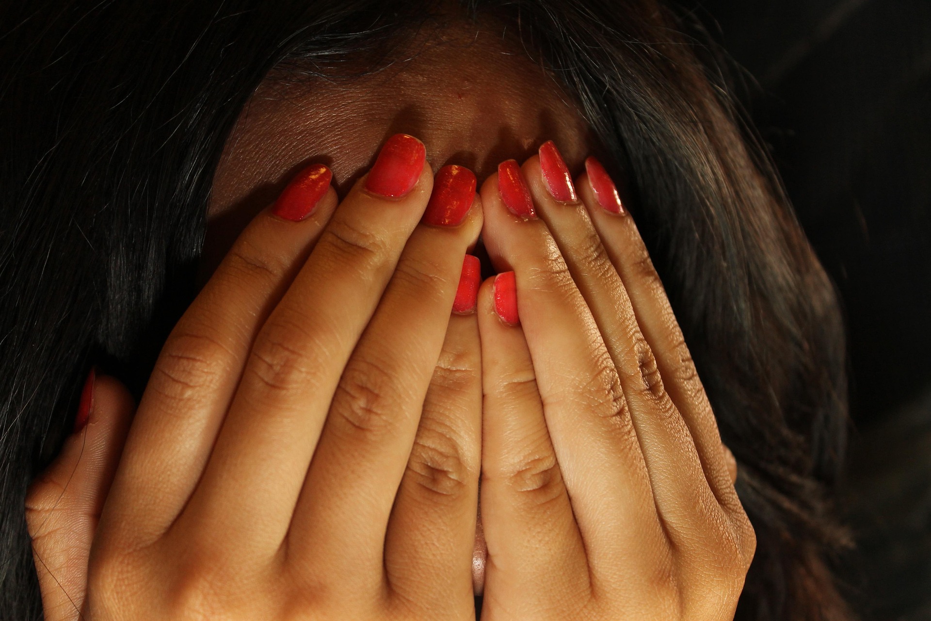 Woman with hands covering face