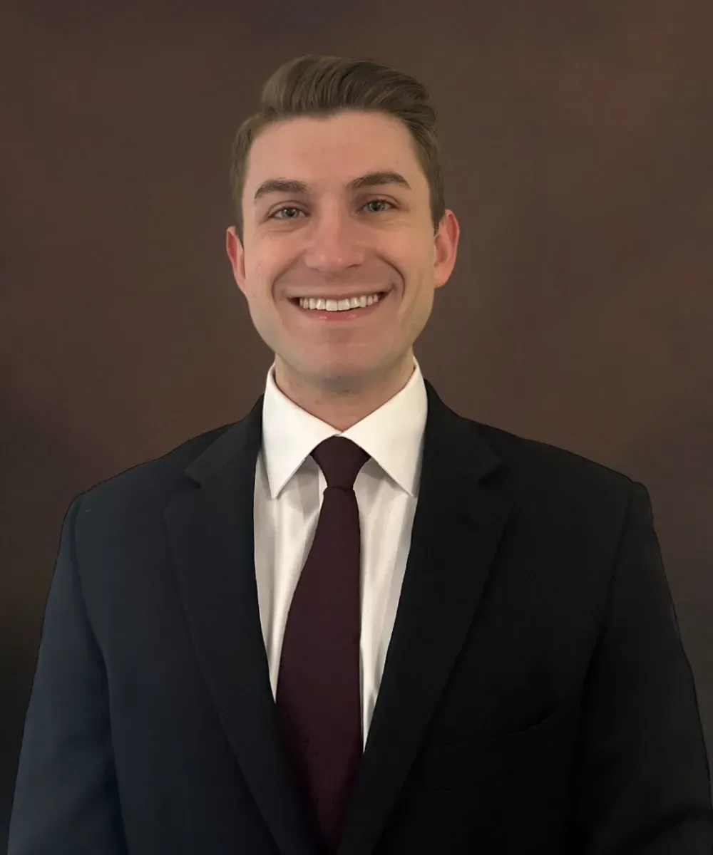 Cole Barkocy, Paraplanner and Customer Service Representative at Assured Group in a suit and tie, smiling
