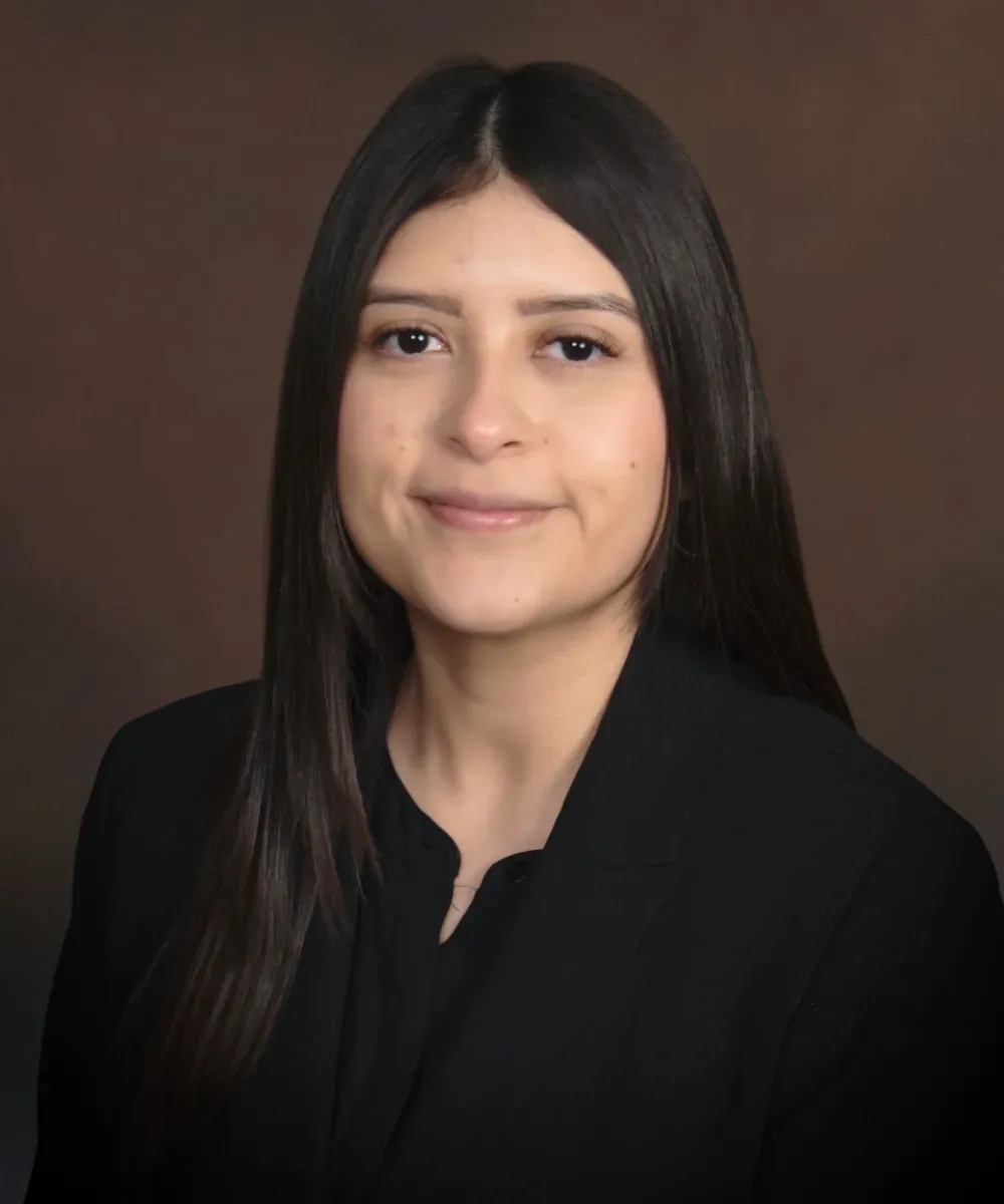 Stephanie Nava, Client Service Manager at Assured Group wearing a black blazer and smiling