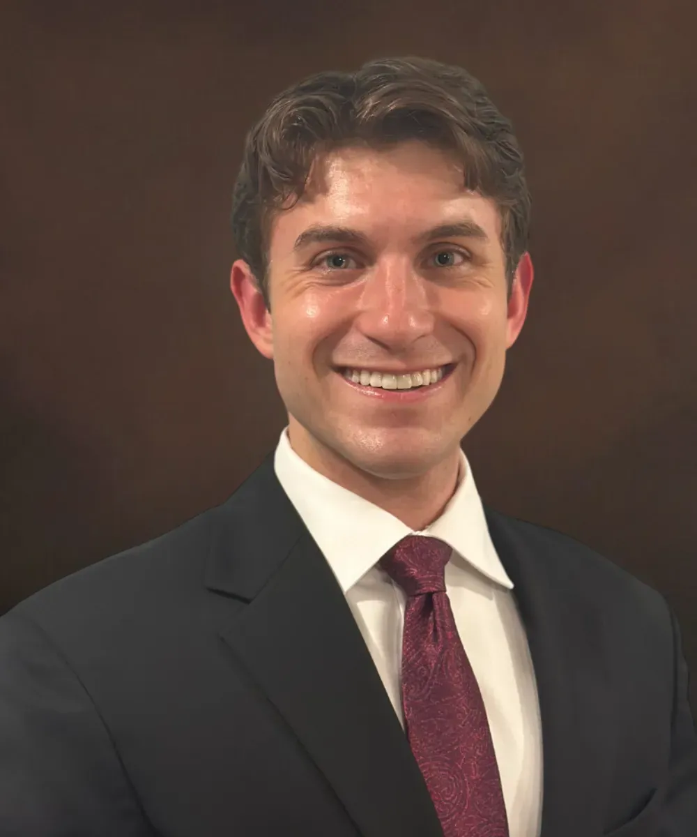Cole Barkocy, Paraplanner and Customer Service Representative at Assured Group in a suit and tie, smiling