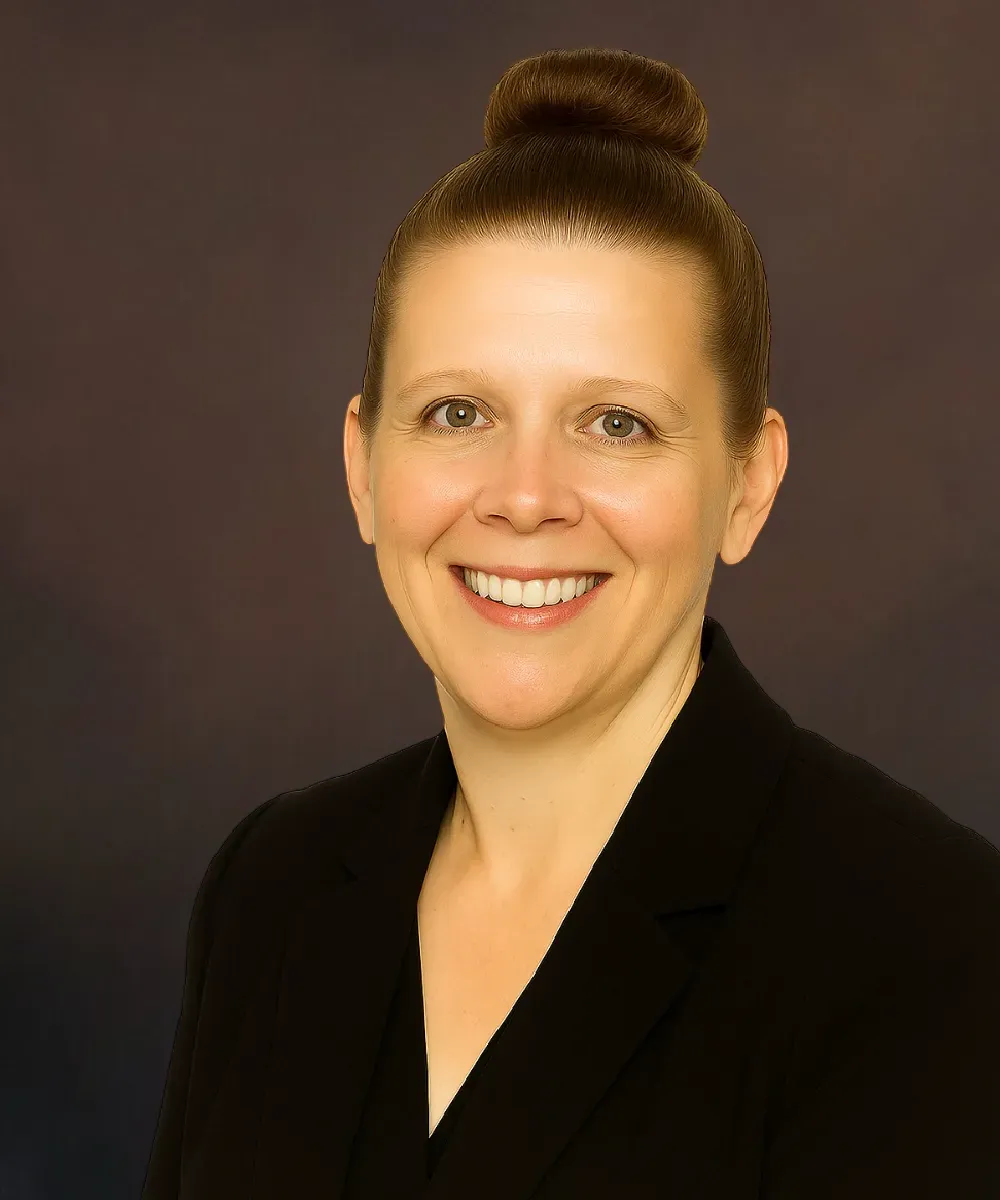 Stacey Lech, Operations Manager and Chief Compliance Officer at Assured Group in a black suit and maroon tie, smiling