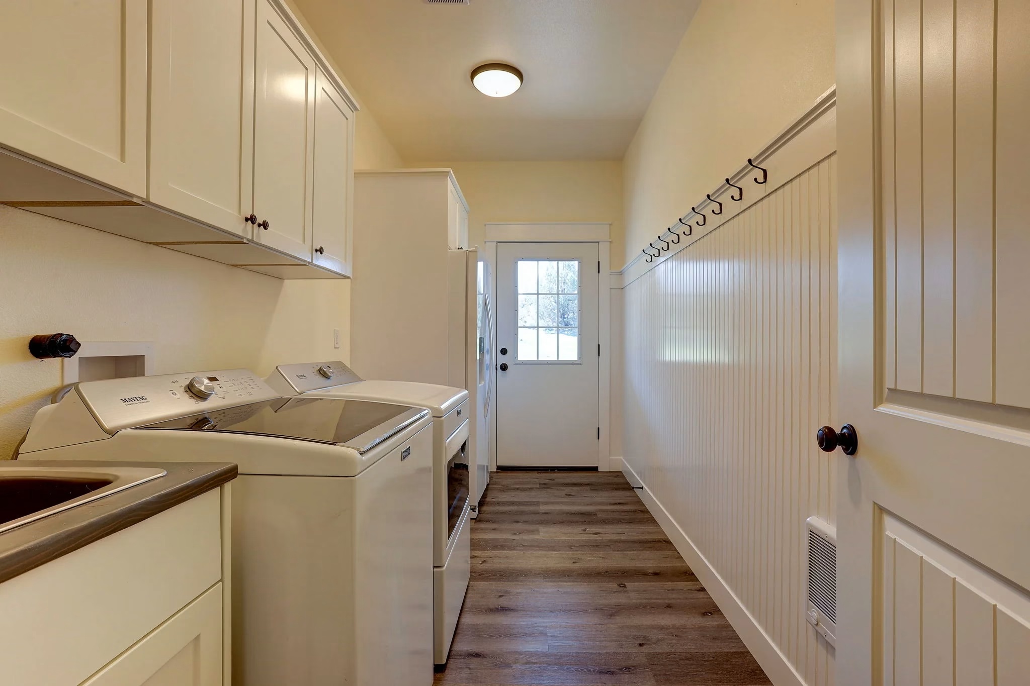 Laundry room with hardwood flooring
