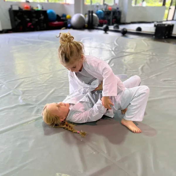 We can see two young students practicing jiu-jitsu at the renowned Renzo Gracie Academy situated in Lake Worth. The pair of beginners are focused on learning the fundamental techniques of the discipline, showcasing how martial arts instill discipline and dedication from an early age. The academy, acclaimed for its comprehensive curriculum, boasts some of the best instructors, who provide their students with personalized attention and guidance, ensuring their steady growth and development. Through consistent and rigorous training at the Renzo Gracie Academy, these promising youngsters are bound to acquire the requisite skills and knowledge to excel in jiu-jitsu competitions and enhance their overall physical and cognitive prowess.