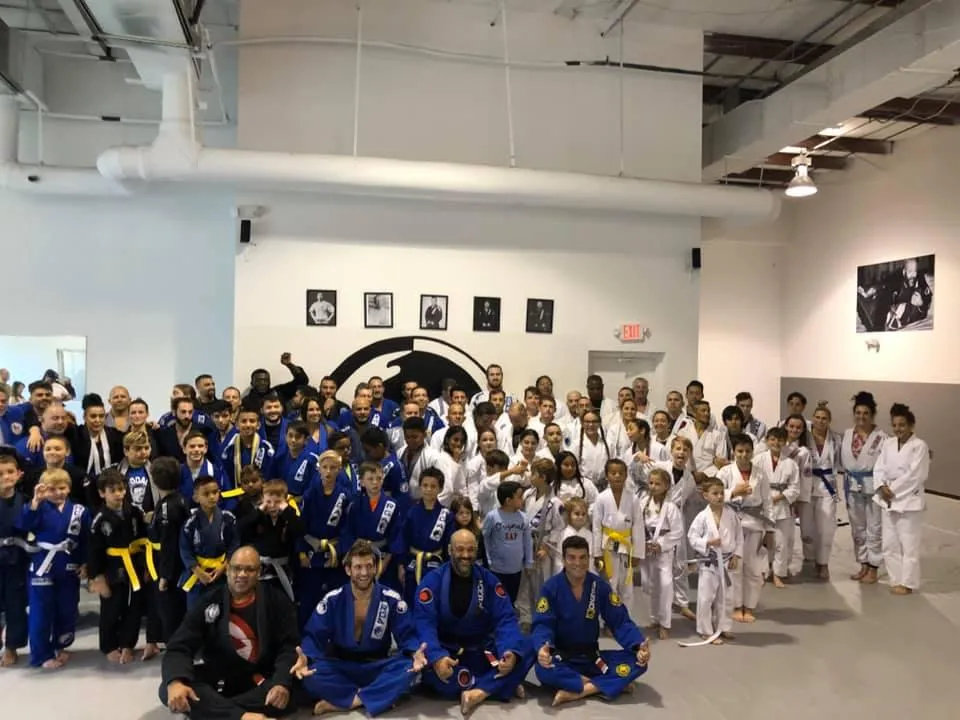 A diverse group of dedicated martial artists practicing advanced techniques at Renzo Gracie Jiu-Jitsu Academy of Weston, featuring seven accomplished black belts proudly wearing their rank, as they train alongside enthusiastic beginners and intermediate practitioners, creating a thriving and inclusive environment for personal growth and skill development in the art of Brazilian Jiu-Jitsu.