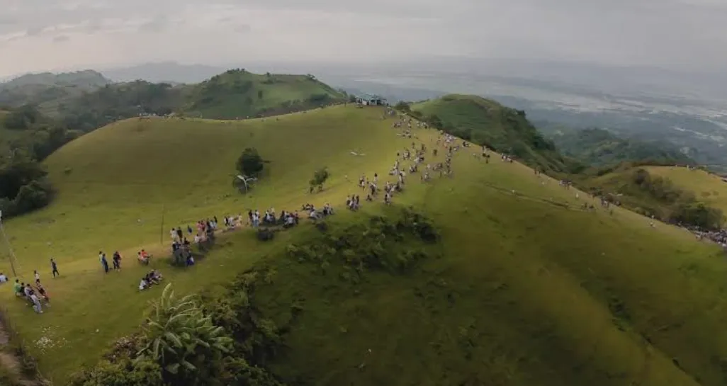Clouds and mist rolling over grassy hills of Tigbao Highlands