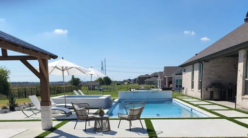 a small pool with lounge chairs next to it
