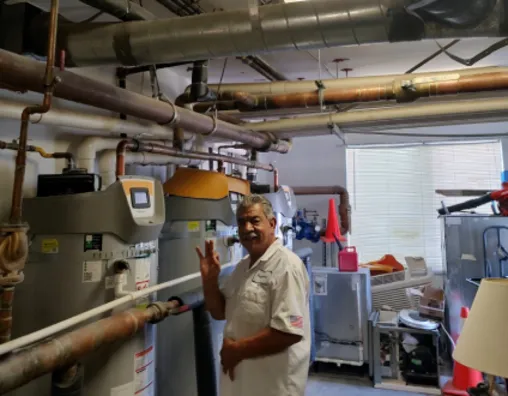 Man standing next to multiple water heaters fixed