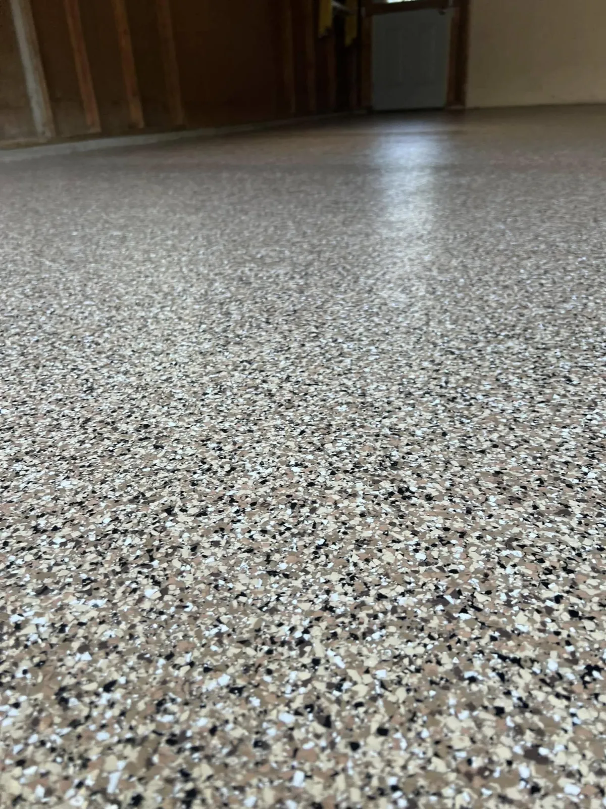 Close-up of durable epoxy garage floor coating with a speckled finish in DFW Metroplex home