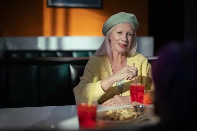 A woman with dementia sits at a table in her own home while speaking with her specially trained dementia care provider that she found through Sumner In-home Care and Preferred Care at Home