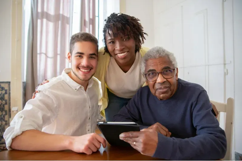 and elderly man coming to the end of his transition care with two of his caregivers, provided by Sumner In-home Care and Preferred Care at Home