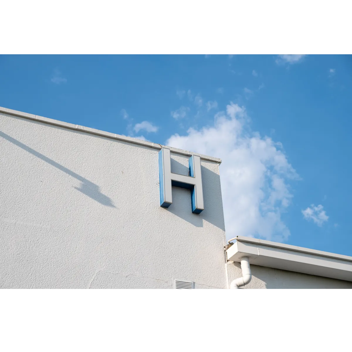 commercial building with the letter "H" on the ide and grey stucco