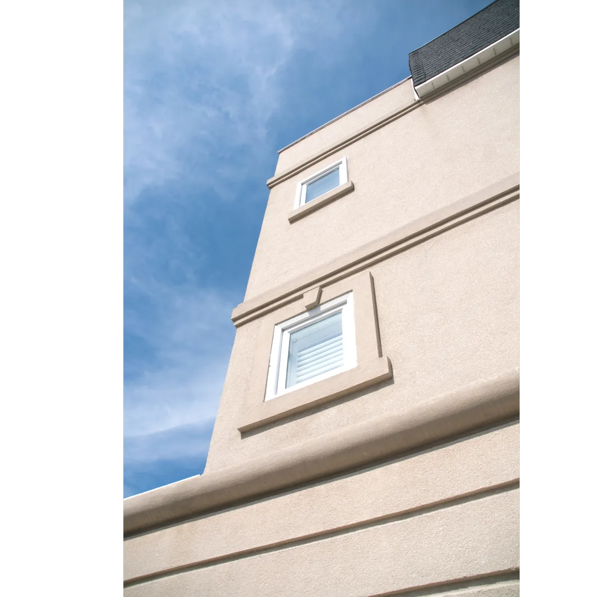 house with pink stucco and two windows