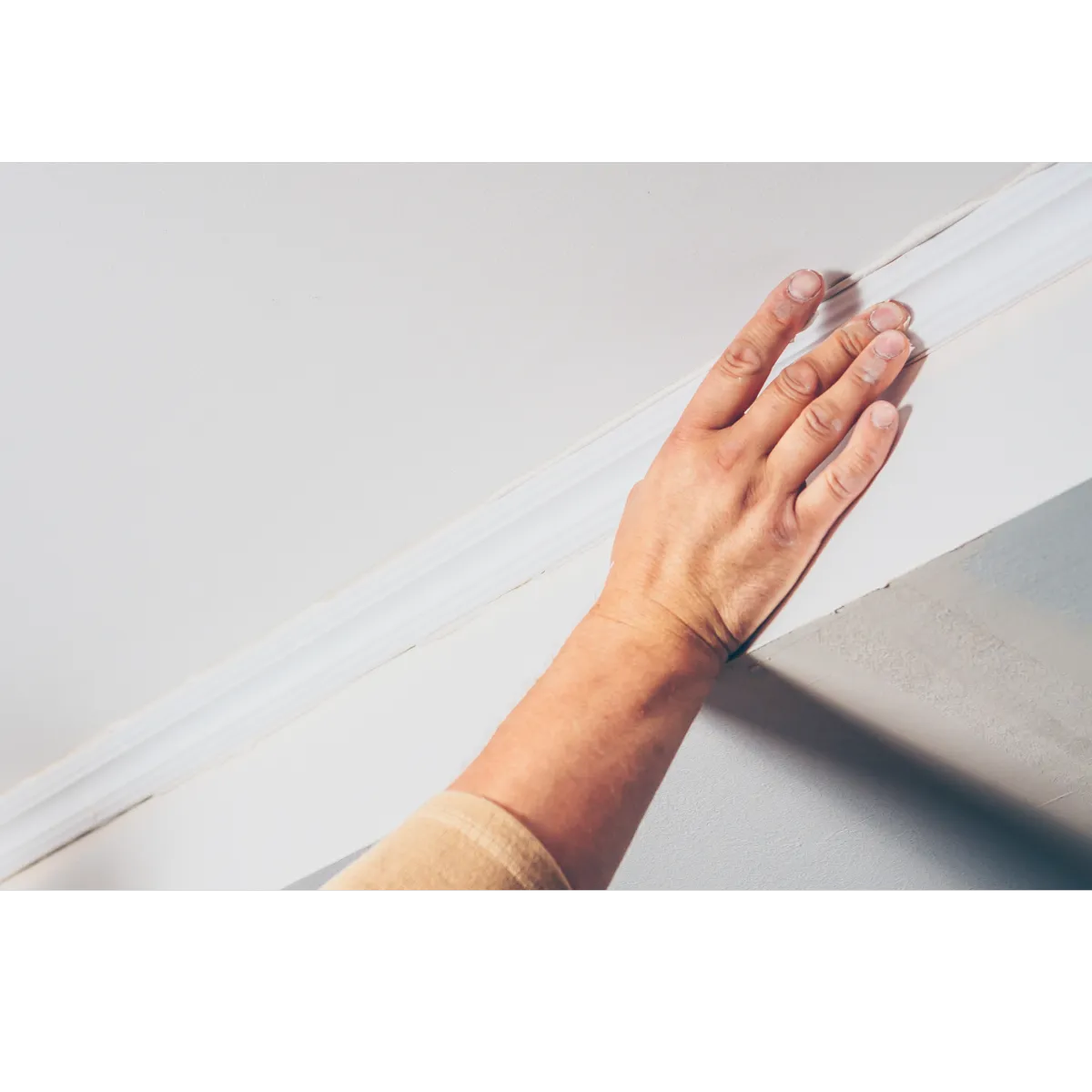 person measuring the grey ceiling of a house