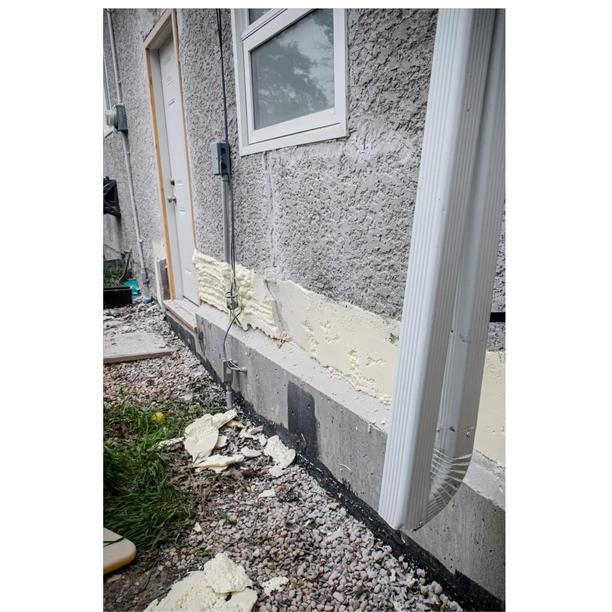 Grey stucco on the house of a house with and tan stucco