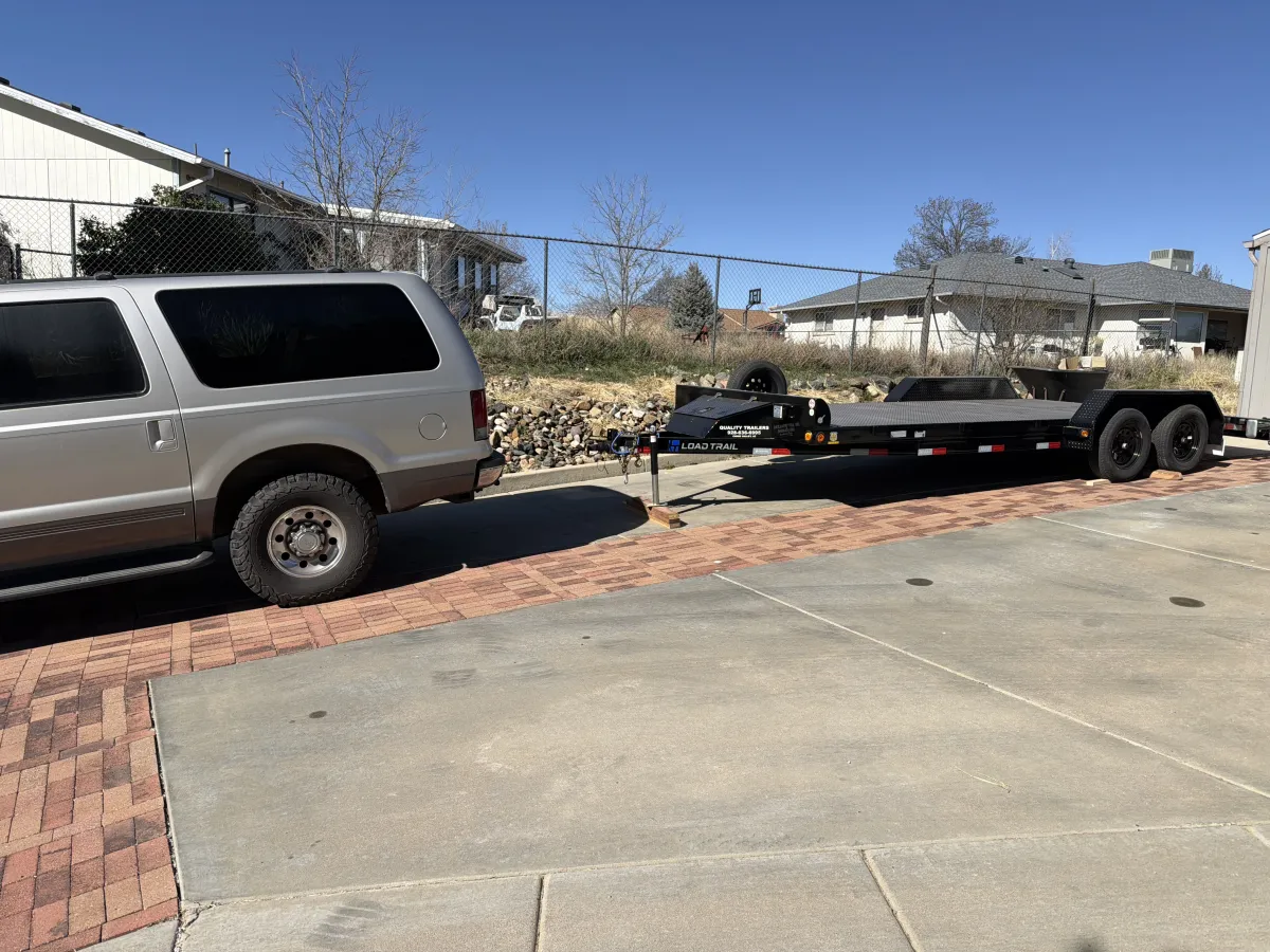 Load Trail car hauler trailer hitched to an SUV in a driveway