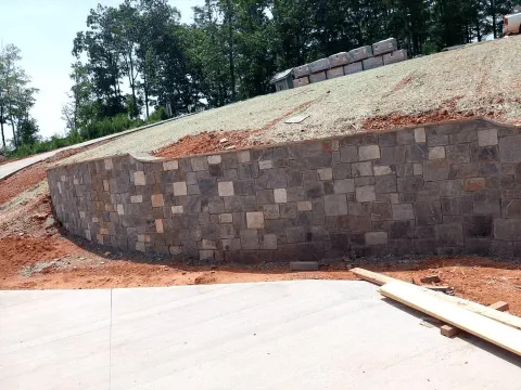 Multi-color stone retaining wall next to driveway