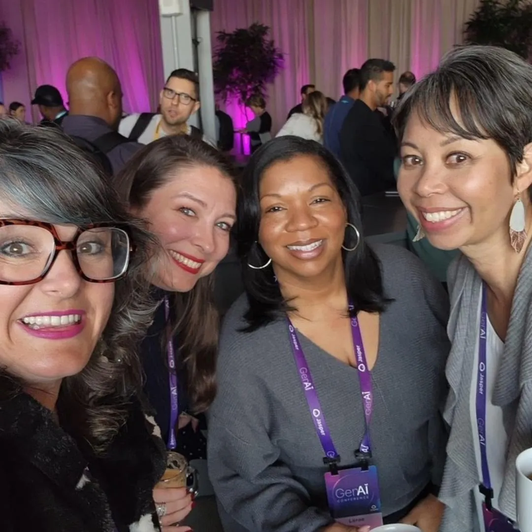 Image of three women all smiling with conference badges around their necks from the Gen AI conference.