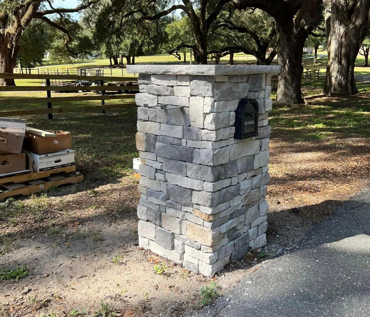A small white house with a brick driveway in front of it.