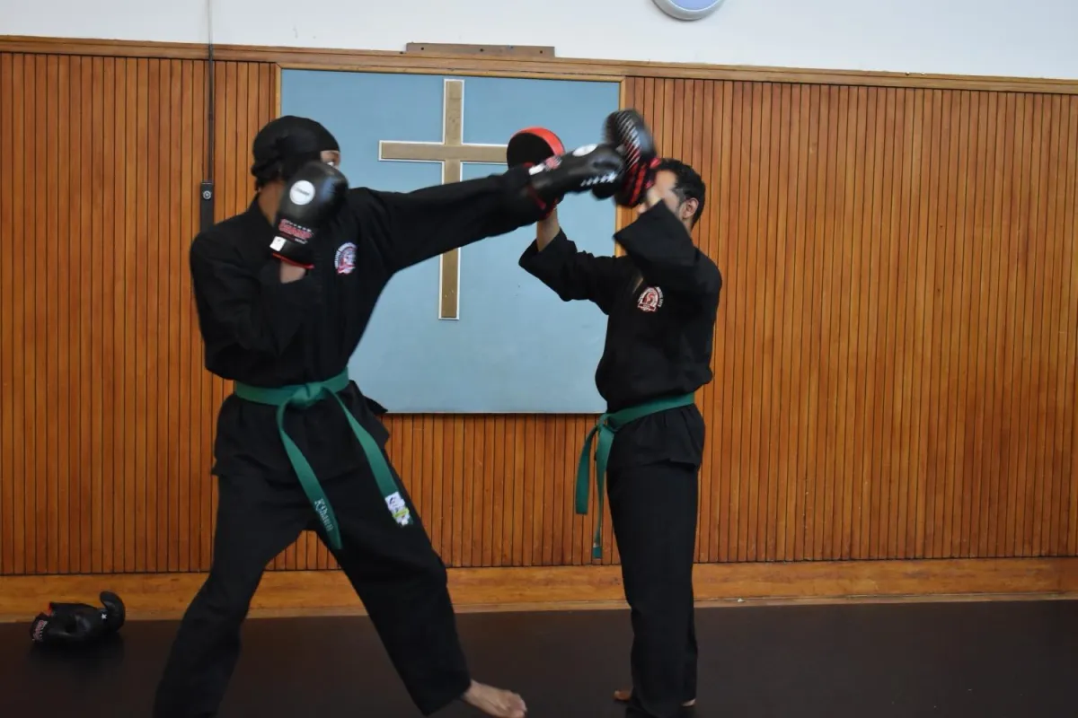 Teens & adults practicing striking drills in martial arts class